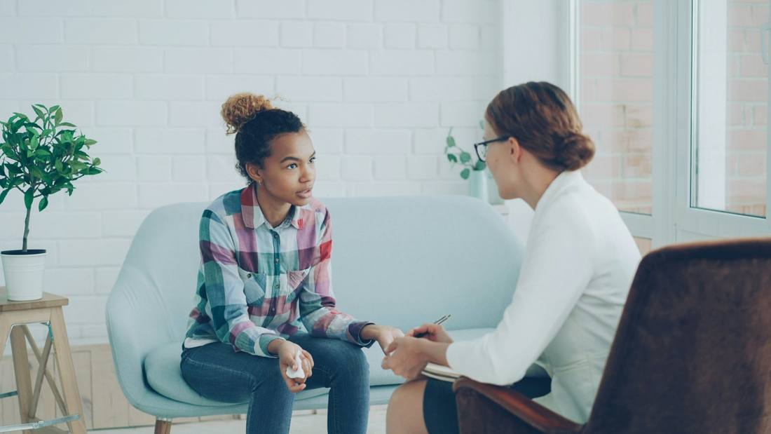 A teen talking with a therapist in a bright office
