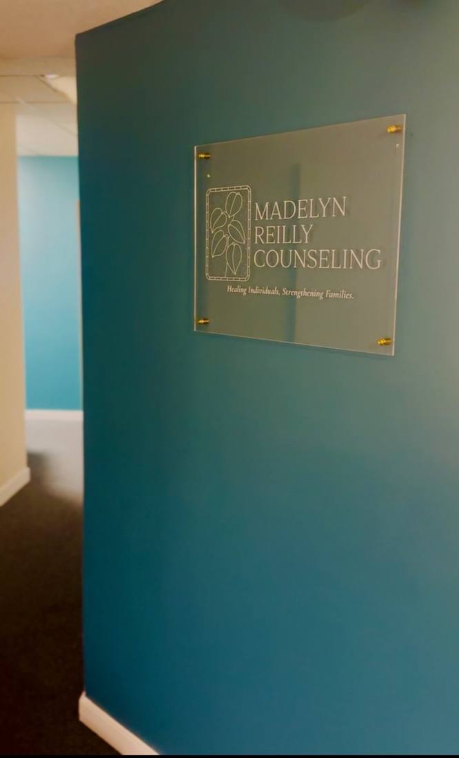 The Madelyn Reilly Counseling sign on a teal wall