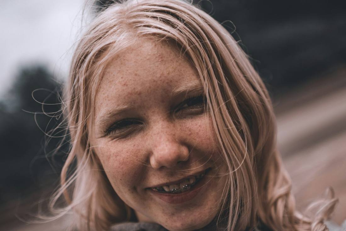 A smiling teen with freckles and braces